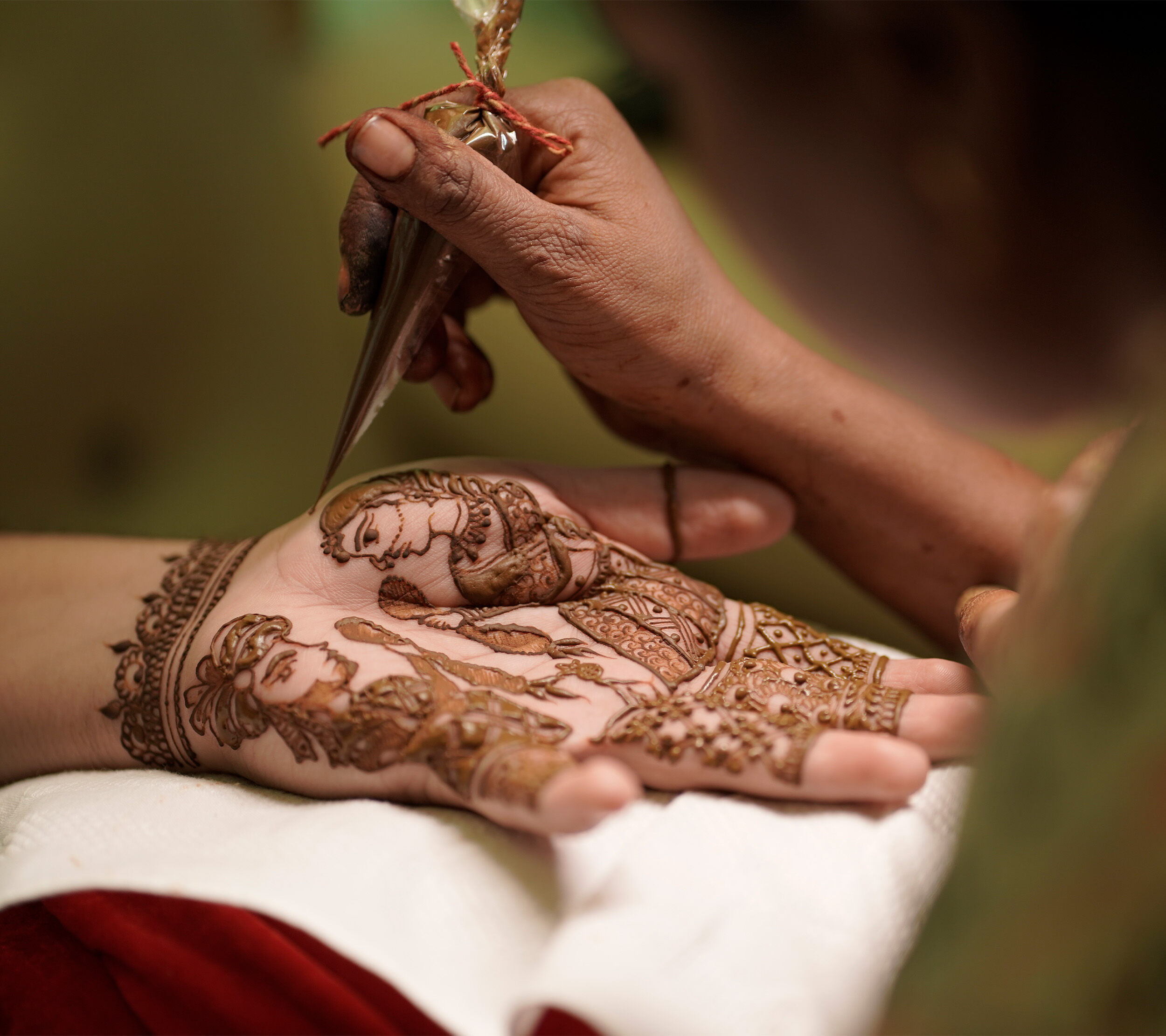 bride getting mehendi done by mehedi artist